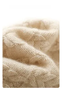 Macro shot of warm beige cable knit texture showing soft cashmere wool yarn details