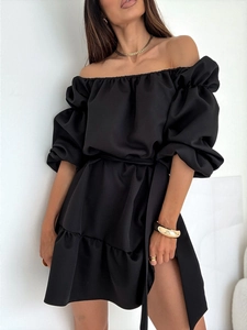 Détail d'une robe noire à épaules dénudées avec manches bouffantes et ceinture