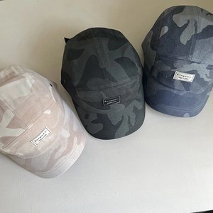Three assorted camo 5-panel camper caps with vintage letter labels in different colors