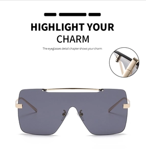 Detailansicht der großen quadratischen Metallsonnenbrille mit grauen Gläsern und Goldgelenken