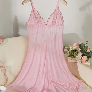 Nuisette rose en dentelle avec imprimé cœur et bretelles réglables sur canapé