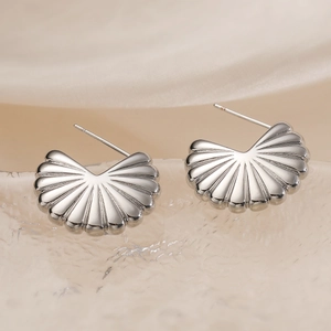 Minimalist shell-shaped gold-plated stud earrings with radial grooves on silk background