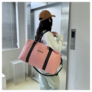 Pink large capacity Oxford travel duffel bag shown on shoulder in a lifestyle setting