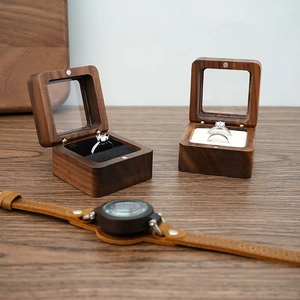 Detail of wooden ring box featuring walnut grain with glass lid and velvet interior