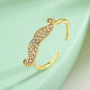 18K gold-plated geometric open ring with cubic zirconia on a green textured surface