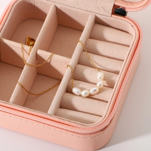 Pink portable jewelry box with pearl necklace organizer and velvet compartments