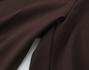 Close-up of deep brown fabric texture on high-quality straight trousers