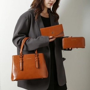 Three-piece brown leather tote bag set with envelope clutch and long zipper wallet
