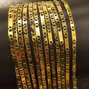 Detailed macro of 18K gold plated stainless steel rectangle link chains with engraved patterns