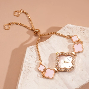 Macro detail of rose gold clover watch dial with sparkling rhinestones and adjustable strap