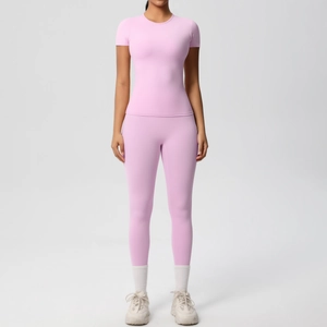 Detail of light pink high-stretch yoga set featuring slim fit t-shirt and matching leggings
