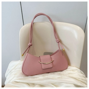 Detail of pink leather baguette bag with crescent gold buckle and knotted shoulder strap