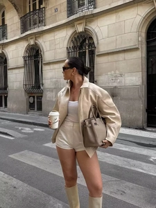 Dettaglio della giacca in pelle beige oversize con ampi revers e trama di qualità