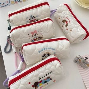 Detail of white quilted pencil case featuring cute puppy embroidery and red zipper