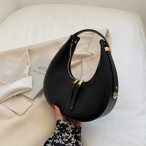 Elegant black leather crescent moon shoulder bag with gold hardware and zipper detail
