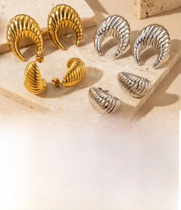 Detailed view of C-shaped threaded earrings in gold and silver vacuum plated titanium steel