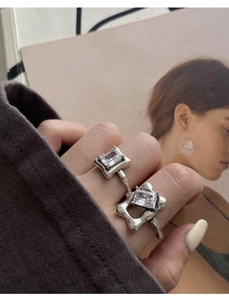Close-up of 925 sterling silver rings with square crystals and wavy band design