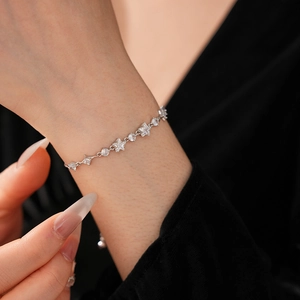 Close-up of sparkling zircon star bracelet on wrist with elegant silver-plated chain