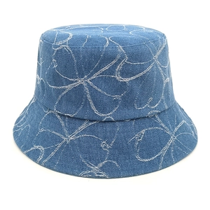 Detail of washed denim bucket hat with white floral pattern and premium stitching