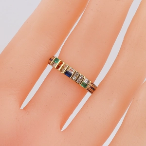 Macro shot of gold band ring featuring colorful rectangular zircon stones in rainbow row