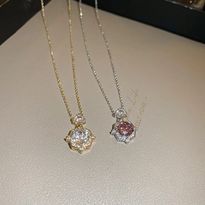 Detailed shot of halo-set zircon flower pendants in gold and silver plating on beige leather