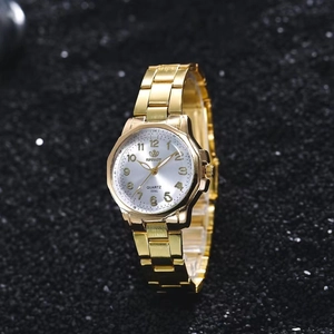 Detailed close-up of a gold-toned quartz watch with a metal band on a black background