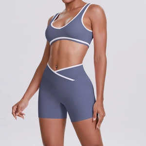 Detail of high-waist crossover yoga shorts and contrast trim sports bra in dusty blue