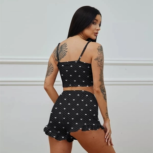 Detail view of black pajamas set with white crown prints and ruffled hem on the shorts