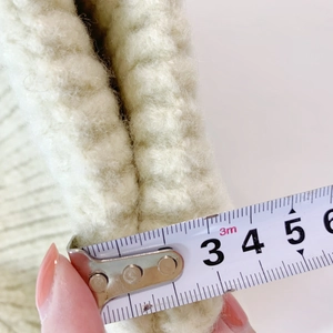 Detailed view showing the 3.5cm thickness of this plush off-white knitted bear hat