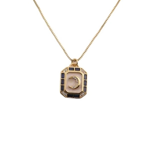 Collier lune plaqué or avec pendentif rectangulaire en émail et cristaux bleus sur fond blanc