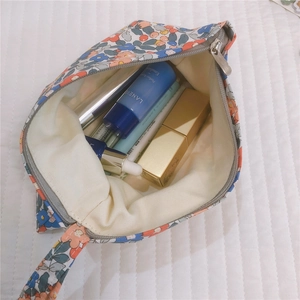 Dettaglio pochette in cotone floreale con interno capiente per rossetti e cosmetici