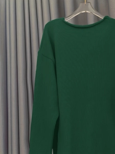 Texture détaillée d'un pull en maille côtelée vert foncé aux motifs de fibres nets