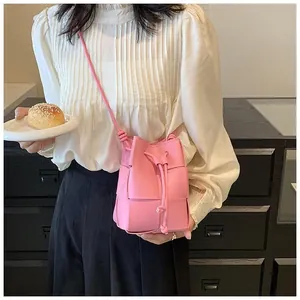 Close-up of pink leather woven bucket bag featuring drawstring closure and textured finish