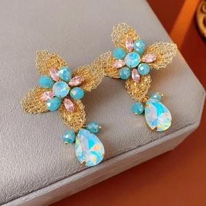 Detail of vintage flower earring with turquoise beads and teardrop crystal on velvet
