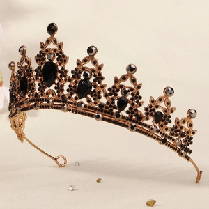 Macro shot of gold tiara featuring intricate black gemstones and glittering rhinestones