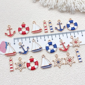 Detail view of nautical alloy charms with ruler showing size of anchor and sailboat