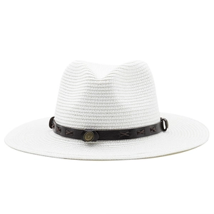 Detail of white Fedora straw hat featuring brown leather band with metallic relief studs