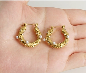 Detail of 18K gold-plated U-shaped earrings featuring pearls and sparkling rhinestones