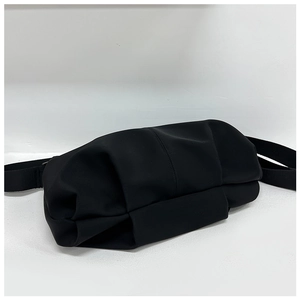 Detailed view of the matte black nylon pleated dumpling bag with adjustable shoulder strap