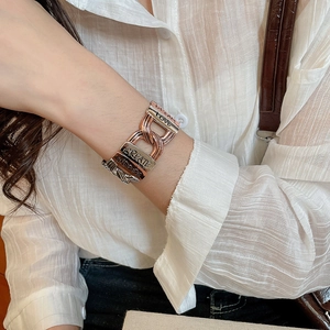 Detail of two-tone metal bracelet with engraved words Dream, Love, and Inspire