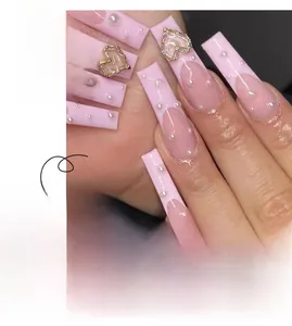 Macro shot of long coffin press-on nails featuring pink French tips with heart jewels and pearls