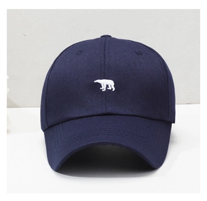 Detailed close-up of navy cotton baseball cap featuring a white polar bear embroidery