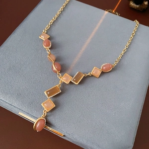 Detailed macro view of vintage gold necklace with orange and brown gemstone pendant