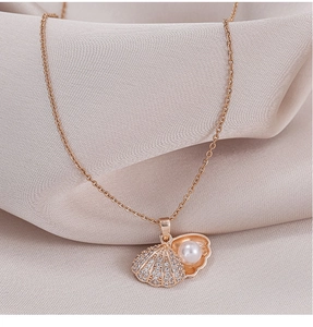 Detail of rose gold shell pendant with white pearl and pave zircon on nude satin cloth