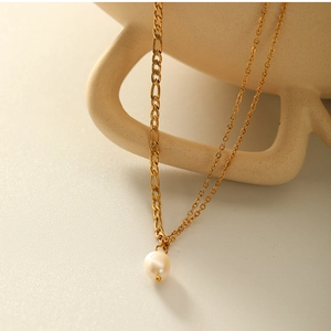 Detail shot of double-layered 18K gold titanium necklace with a white freshwater pearl