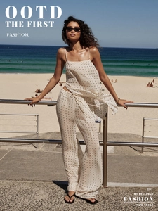 Close-up of polka dot crop top and high-waisted trousers on a sunny beach setting