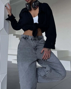 Detail view of high-waist wide-leg grey wash denim jeans with relaxed fit and soft drape