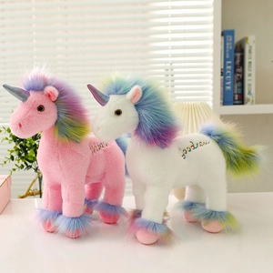 Bunte Einhorn-Plüschtiere mit Regenbogenmähne und Stickerei in warmer Wohnatmosphäre