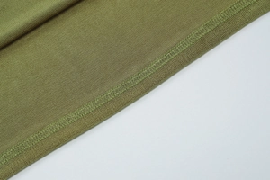 Macro shot of olive green knit dress fabric showing detailed texture and lockstitch seams