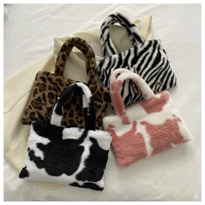 Flat lay of small plush shoulder bags in leopard, zebra, cow, and pink patterned faux fur